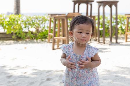 亚洲人漂亮的婴儿女孩演奏沙向指已提到的人海滩.