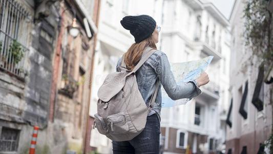 年幼的旅行者女人有样子的地图采用在户外