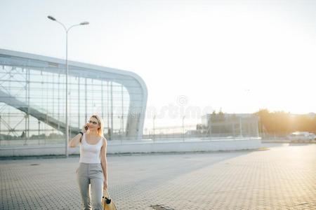 商业女人讲在旁边电话在期间起立采用户外的