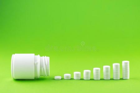 关在上面金字塔观念关于白色的药丸和瓶子向绿色的背