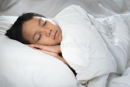 男孩睡眠向床和白色的纸和枕头