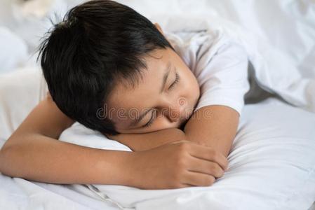 男孩睡眠向床和白色的纸和枕头