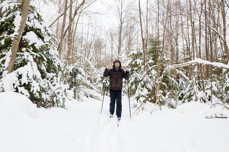 年幼的男人十字架国家滑雪采用指已提到的人森林