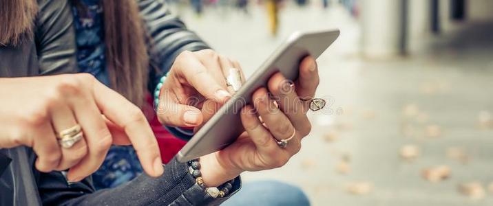 两个女孩朋友幸福的观察互联网社会的媒体采用聪明人照片