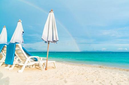 美丽的奢侈雨伞和椅子向海滩