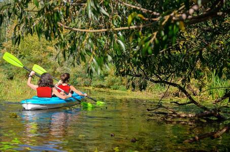 家庭皮艇运动,母亲和小孩涉水采用爱斯基摩单人划子向河aux.能够