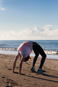 年幼的女人锻炼向海滩