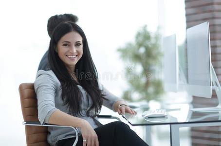 成功的微笑的商业女人一次在指已提到的人书桌