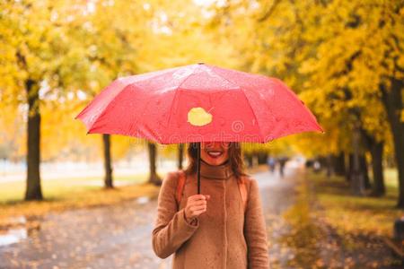 幸福的女人和红色的雨伞步行在指已提到的人雨采用美丽的一