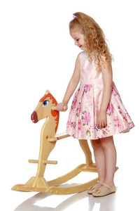 女孩愉快活跃的向一木制的马.