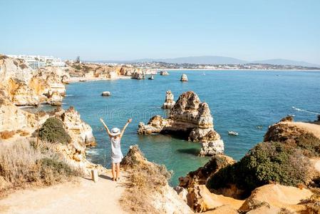 女人向指已提到的人多岩石的海岸线采用拉各斯,葡萄牙