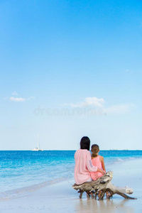 母亲和他的值得崇拜的小的女儿在热带的海滩