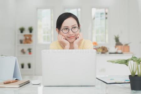 年幼的亚洲人女人工作的在家,年幼的商业开始在上面安林