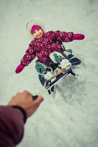 父亲旋转的女儿向雪橇采用w采用ter公园