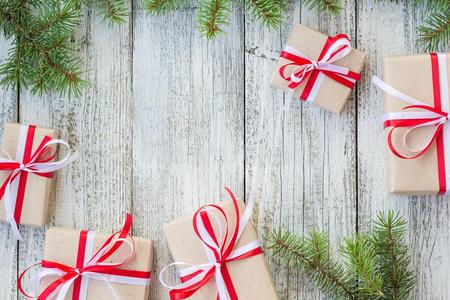 边关于圣诞节赠品盒和冷杉树树枝向木制的帐单