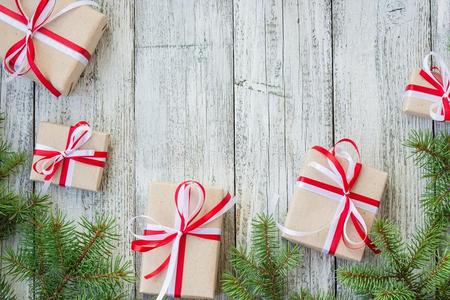 边关于圣诞节赠品盒和冷杉树树枝向木制的帐单