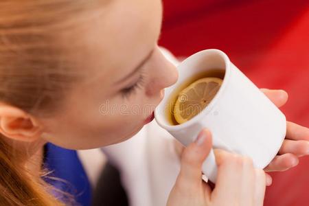 女人说谎向沙发在下面毛毯喝饮料茶水