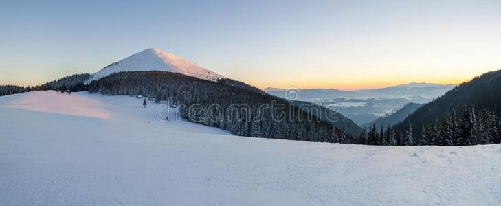 全景的看法关于下雪的冬喀尔巴阡山脉的山在日落
