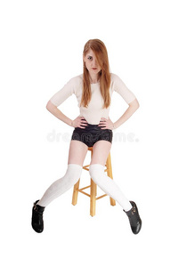 美丽的女人一次采用短裤一高跟鞋向椅子