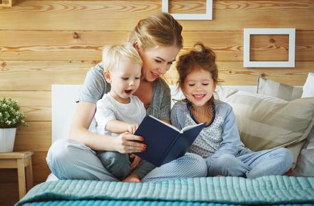 家庭母亲阅读向孩子们书采用床