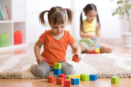 孩子们蹒跚行走的人女儿演奏玩具在家,幼儿园或希腊字母第13字