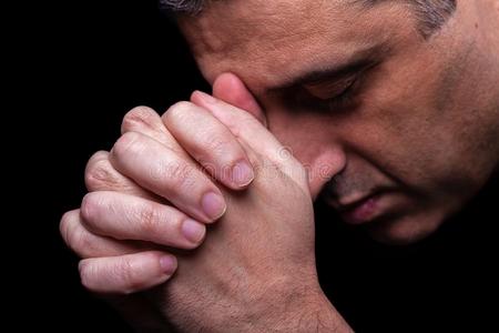 关在上面关于忠实的成熟的男人祈祷,手折叠的采用崇拜