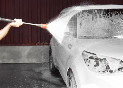 男人清洁汽车和高的压水