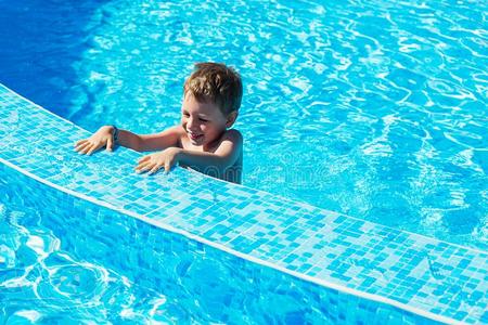 幸福的小孩演奏采用蓝色水关于swimm采用池.小的男孩草地