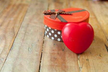 对顶花红色的赠品盒和红色的带和袖珍型的东西心里面的向木材后面照片