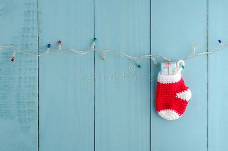 红色的圣诞节短袜绞死和礼物向彩色粉笔颜色木制的walnut胡桃