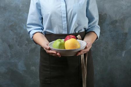 年幼的女人采用围裙hold采用g盘子和多汁的苹果