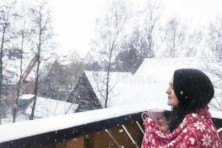 女人和喝和毛毯在下面下雪