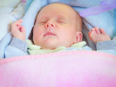小的新生的婴儿睡眠平静地采用毛毯