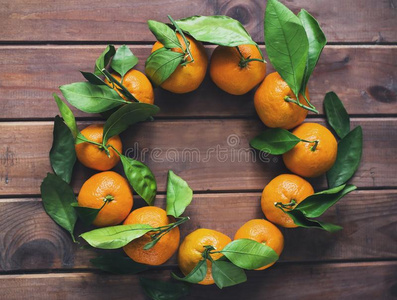 指已提到的人花环关于新鲜的橘子向木制的背景