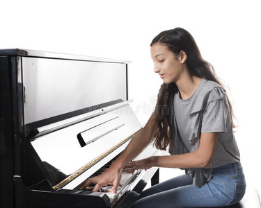 十几岁的黑头发的妇女女孩和黑的直立的钢琴采用工作室