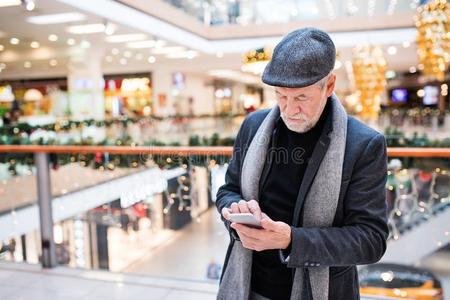 较高的男人和智能手机做圣诞节购物.