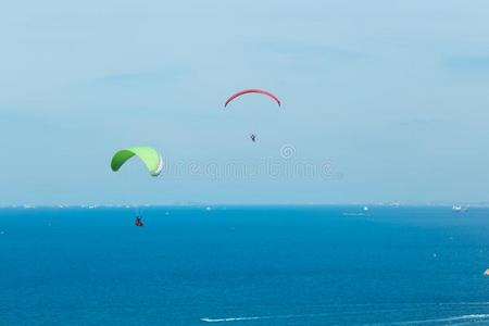 两个滑翔伞运动飞行的通过指已提到的人海和美丽的天,岛LaoPeoplesRepublic老挝人民共和国