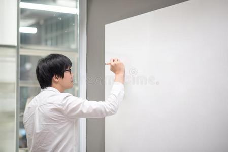 年幼的亚洲人男人文字向白色的板采用meet采用g房间