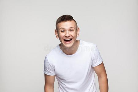 年幼的成功男人有样子的在照相机和露出牙齿的微笑.照片