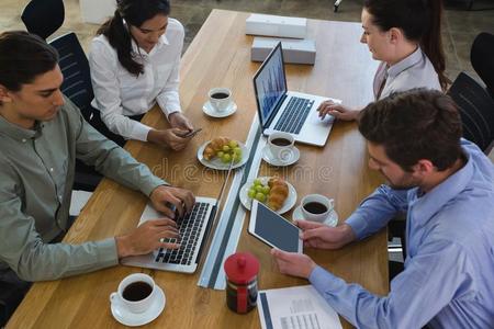 组关于经理谈论和便携式电脑和快餐在书桌