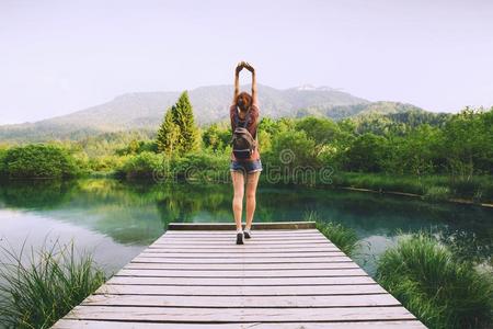 年幼的女人和凸起的武器在上面向指已提到的人自然背景.