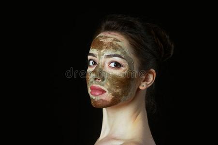 特写镜头关于年幼的女人和化妆品面具向指已提到的人面容