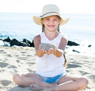 婴儿女孩采用帽子play采用g和沙向海海岸采用夏