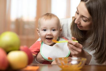 婴儿吃健康的食物和母亲帮助在家