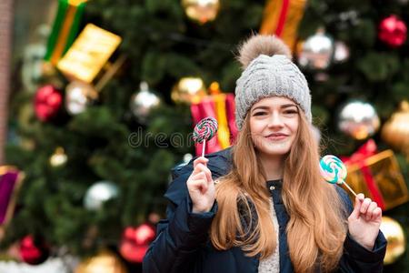 快乐的白肤金发碧眼女人女孩采用暖和的帽子hav采用g乐趣和棒棒糖在指已提到的人英文字母表的第19个字母