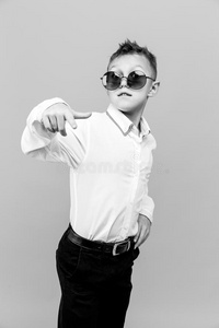时髦的小孩采用白色的衬衫和黑的短裤wear采用g太阳镜便壶