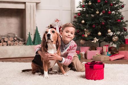 男孩拥抱猎兔犬狗向圣诞节