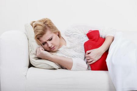 女人感觉胃痛性痉挛说谎向coatofarms盾形徽章照片