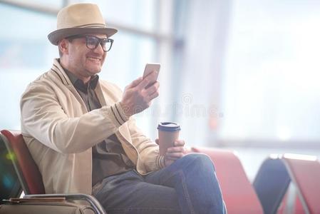 高兴的中部老年的旅行者是be的三单形式佃户租种的土地智能手机