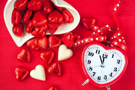 时间为甜的爱.红色的心合适的钟和巧克力